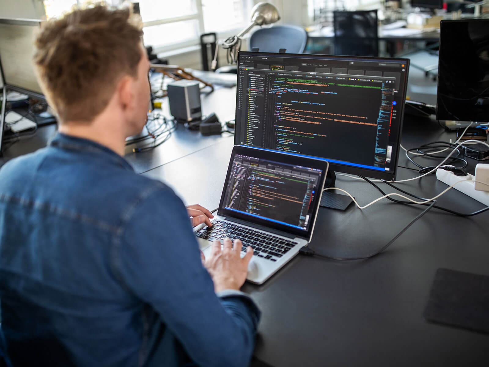 Developer coding on a laptop in an office, symbolizing back-end API development