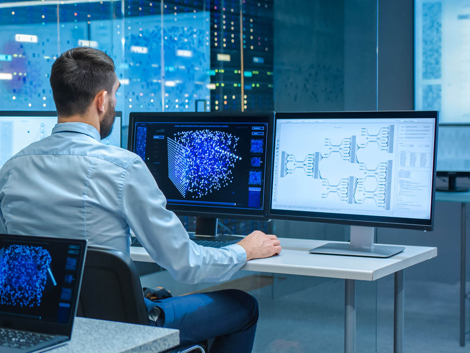 Man examining a workflow algorithm and an interface on dual screens, symbolizing machine learning design work