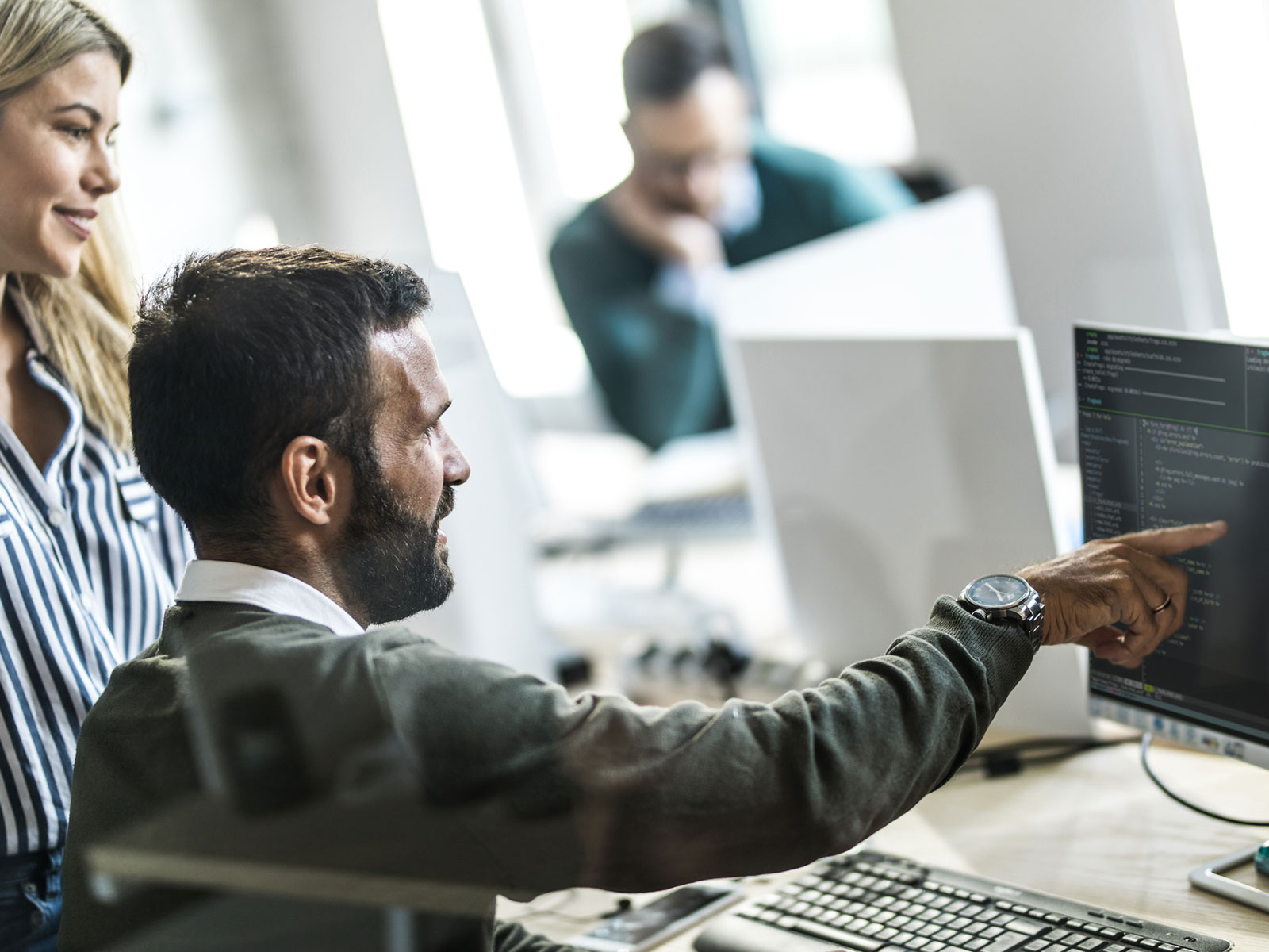 Man and woman discussing details of an application's code, highlighting collaborative software development