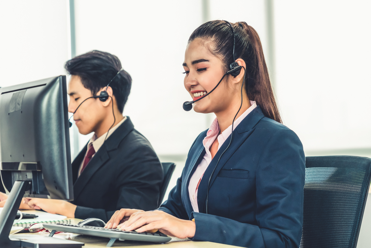 Woman working on a computer with a headset on