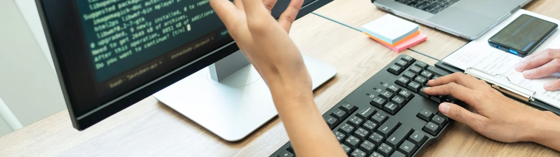 Developer working with AI tools across multiple computer monitors in modern workspace
