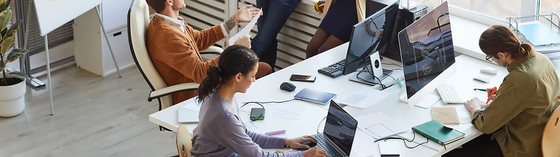 Diverse team of technology professionals discussing IoT security strategies in modern office