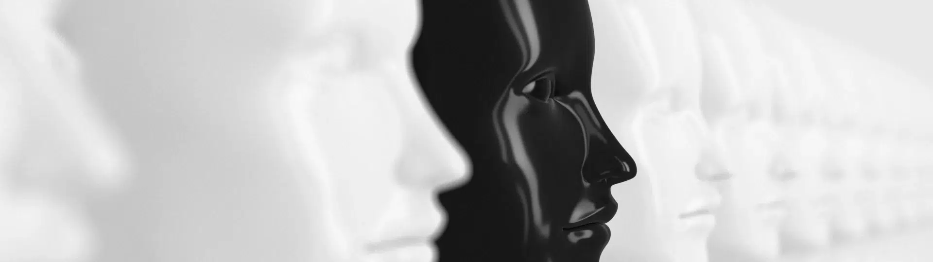 Black mannequin face among white mannequin faces illustrating AI bias and diversity