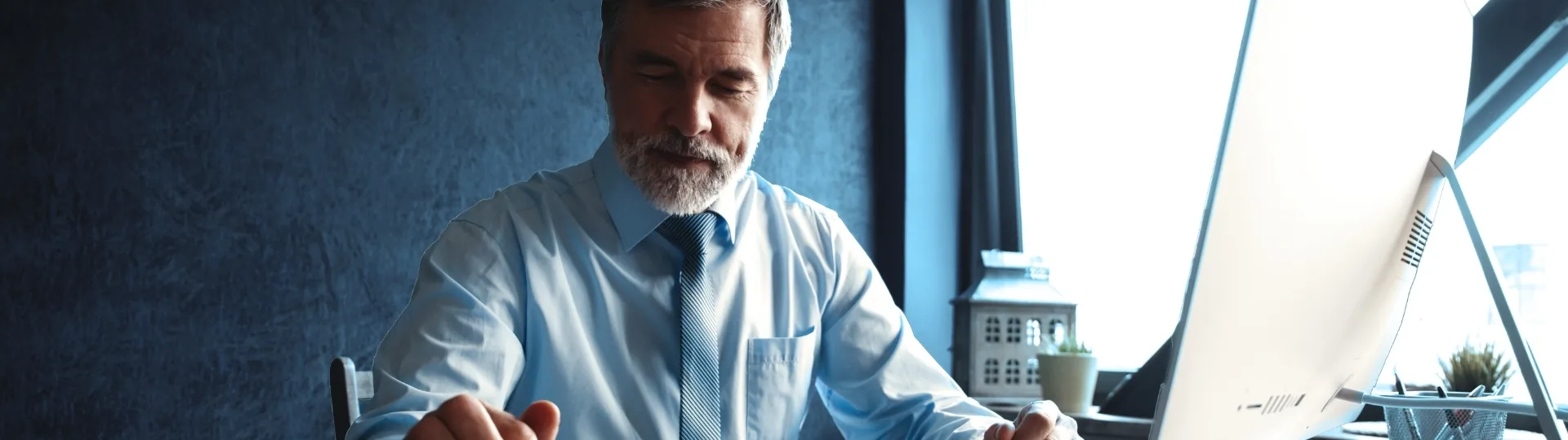 Tech leader reviewing AI strategy at a desktop computer in a modern office setting