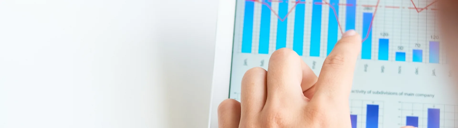 Hand pointing at bar and line chart data visualization on a tablet screen