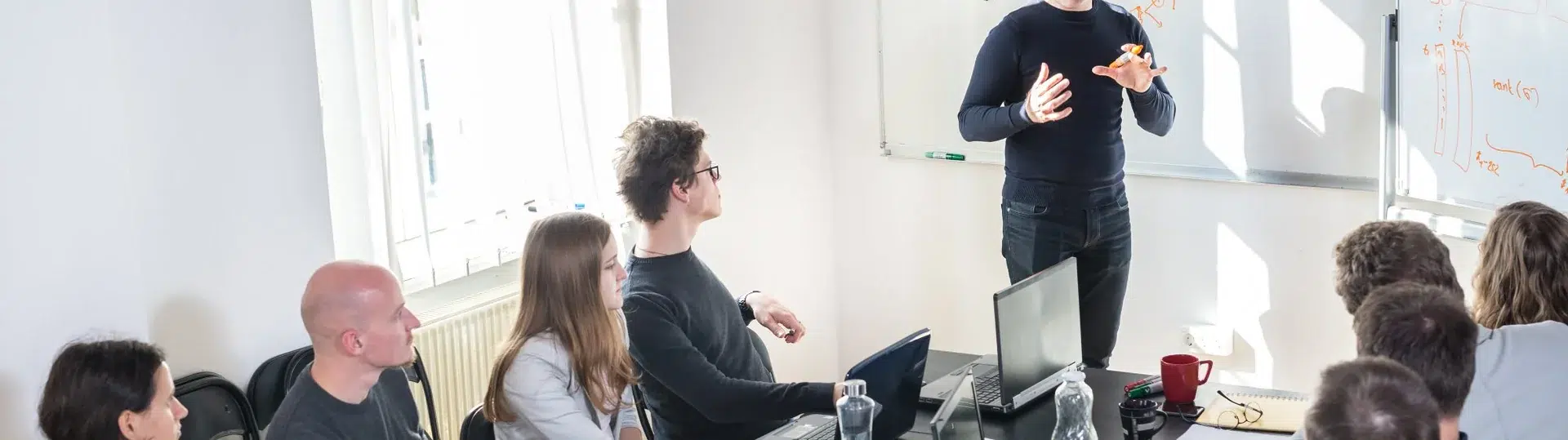 Cloud architecture team engaged in whiteboard planning session with technical diagrams