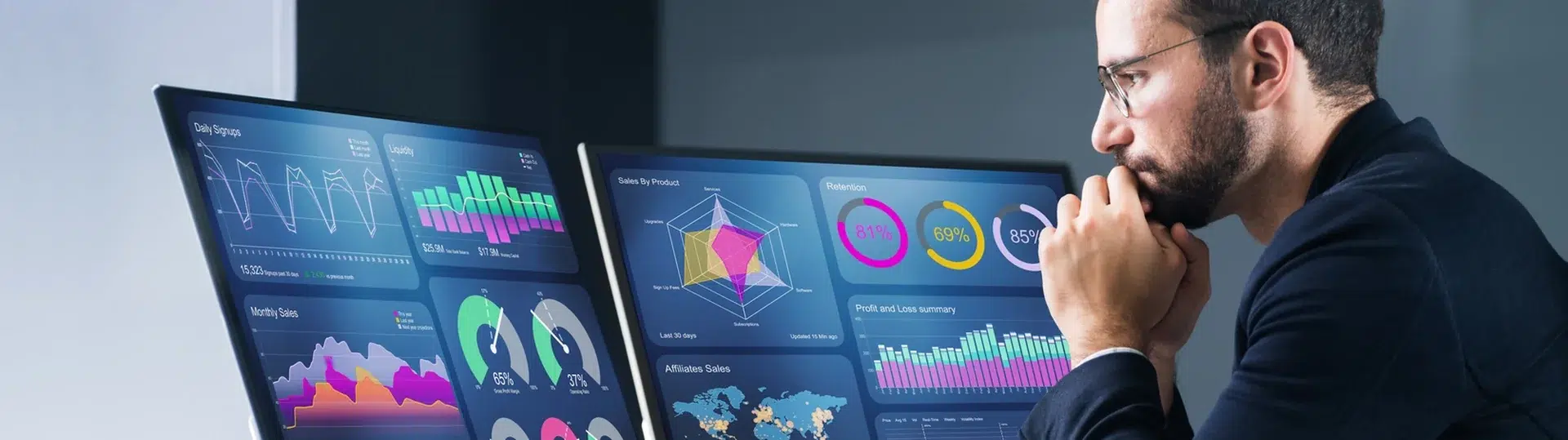 Data analyst studying complex analytics dashboards and charts on dual monitors