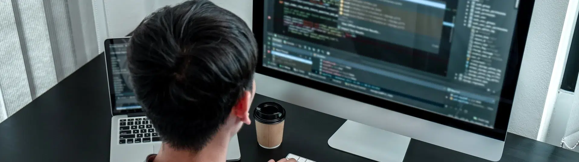 Developer working at multi-monitor desktop workstation