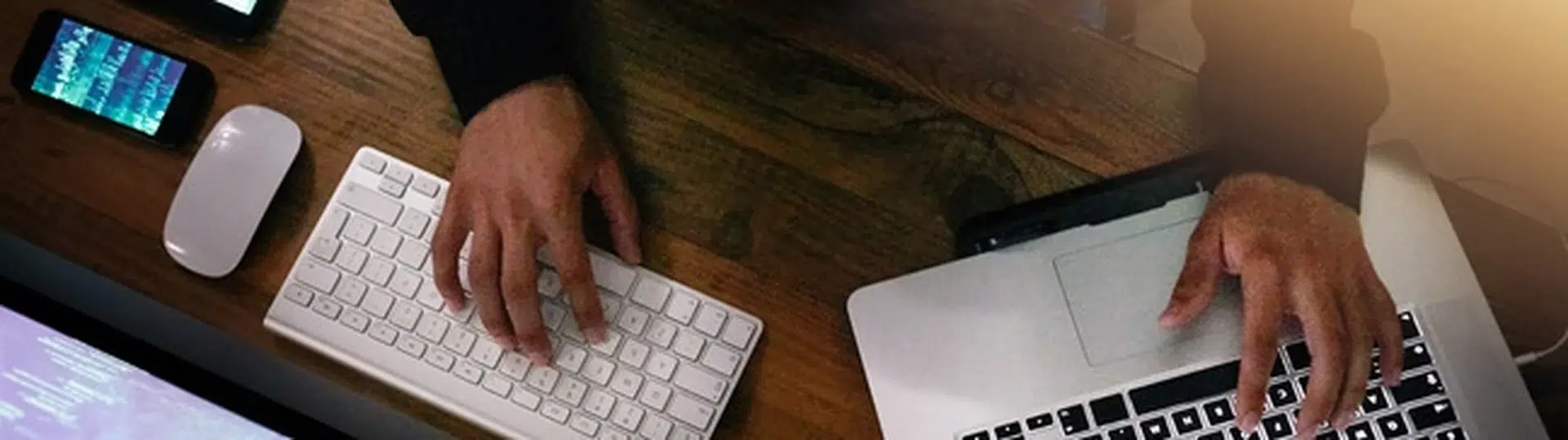 Software developer hands on keyboard laptop overhead view coding