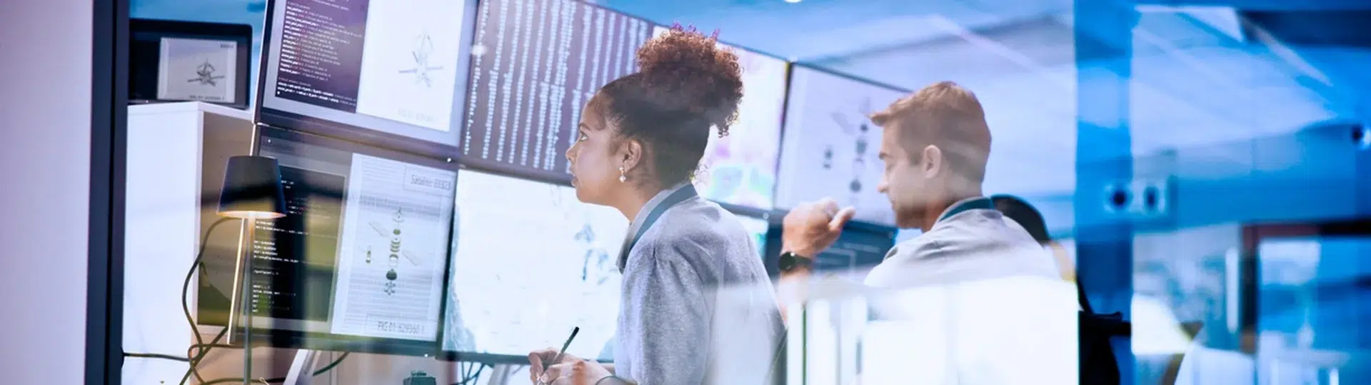 Engineering team monitoring AI-driven systems and analytics dashboards in a modern control room environment