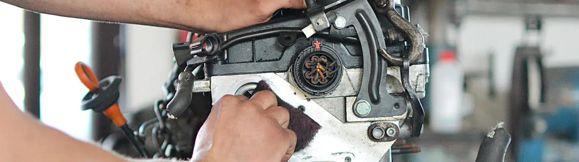 Mechanic working on an engine block in an automotive repair workshop
