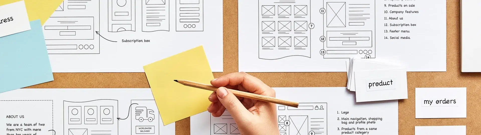 Overhead view of detailed mobile app wireframe mockups and user flow diagrams pinned to a corkboard